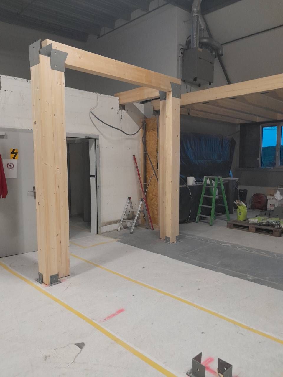 Une grande pièce avec des poutres en bois et une échelle