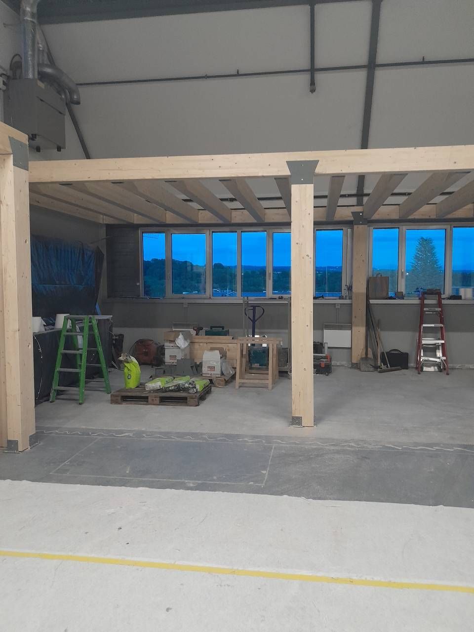 Une grande pièce avec beaucoup de fenêtres et de poutres en bois