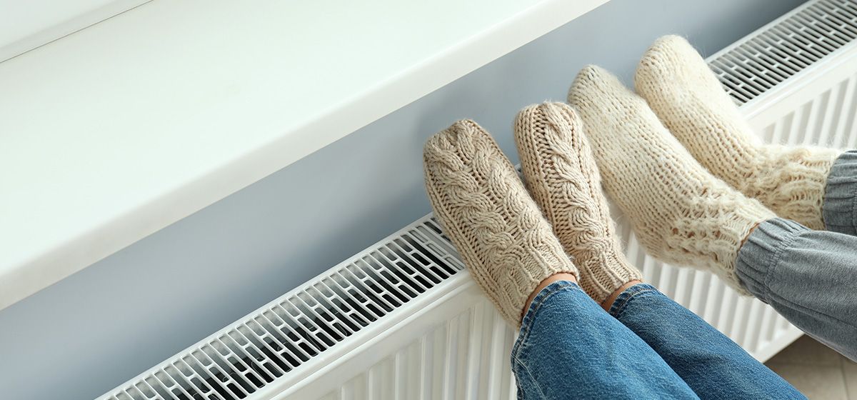 Personnes se réchauffant les pieds sur un radiateur