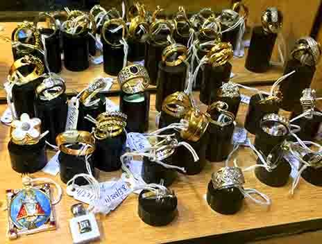 Exhibición de joyas con numerosos anillos en soportes negros; algunos de oro, otros de plata y algunos con gemas.