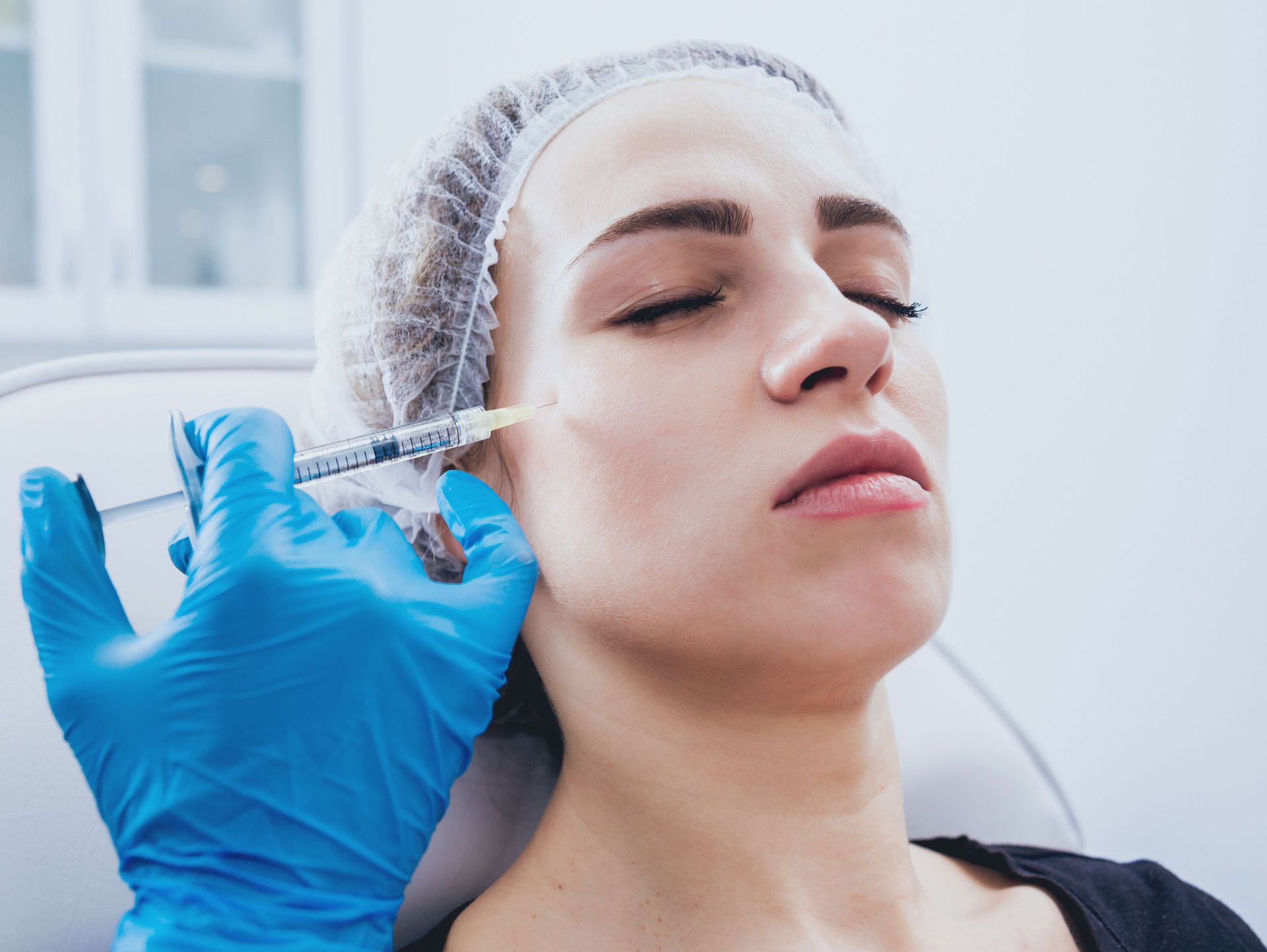 Una mujer recibe una inyección de botox en la cara.