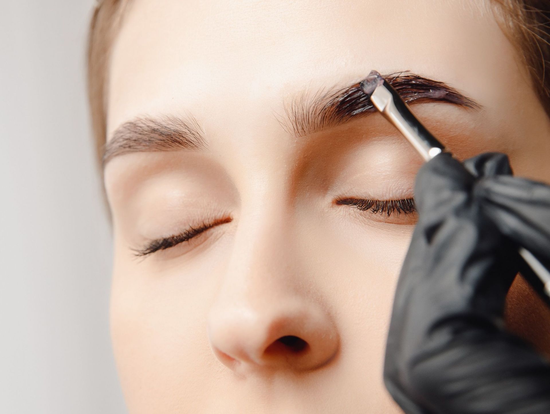 Una mujer se está pintando las cejas con un pincel.