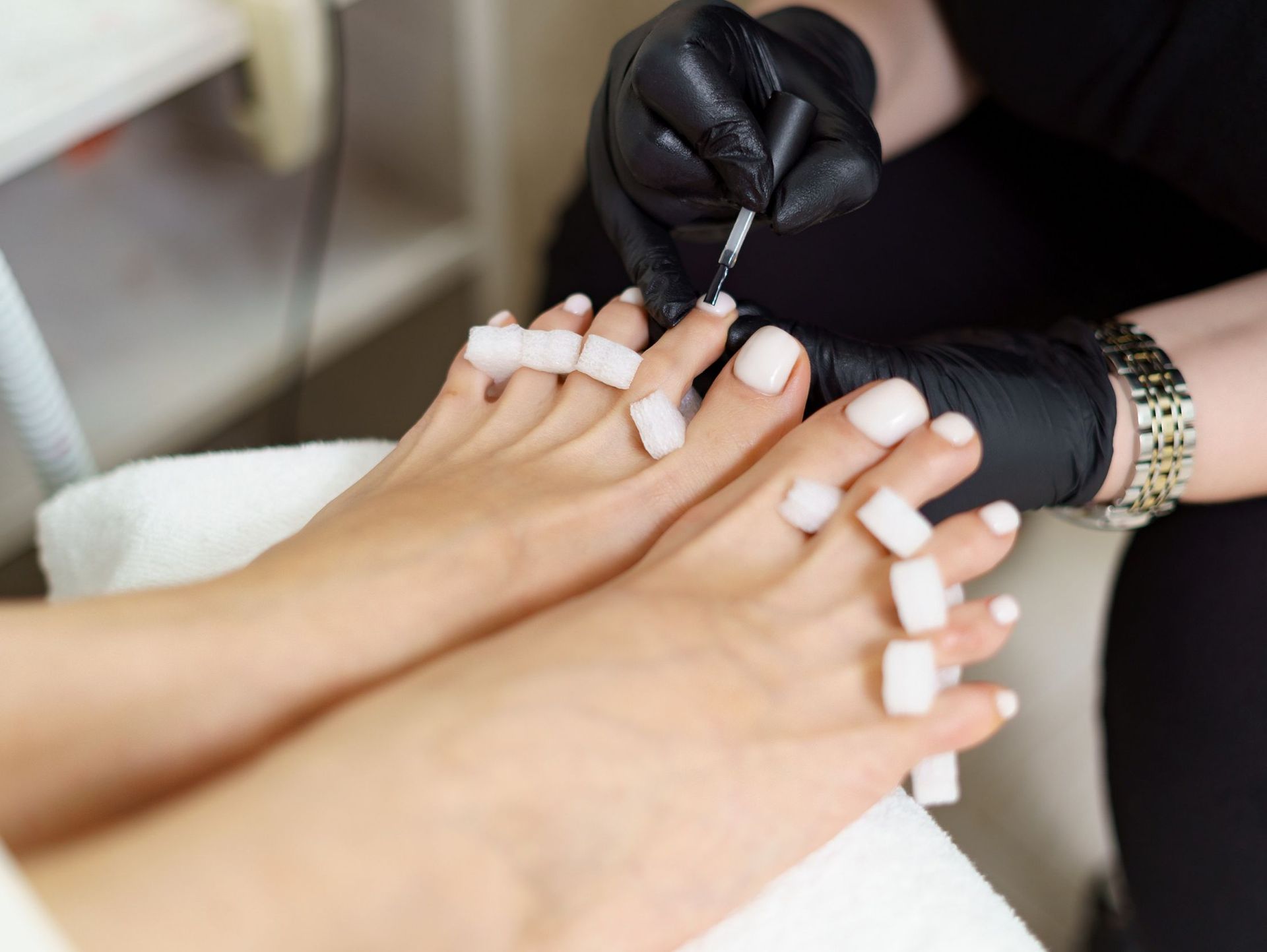 Una mujer se está pintando las uñas de los pies con un artista de uñas.