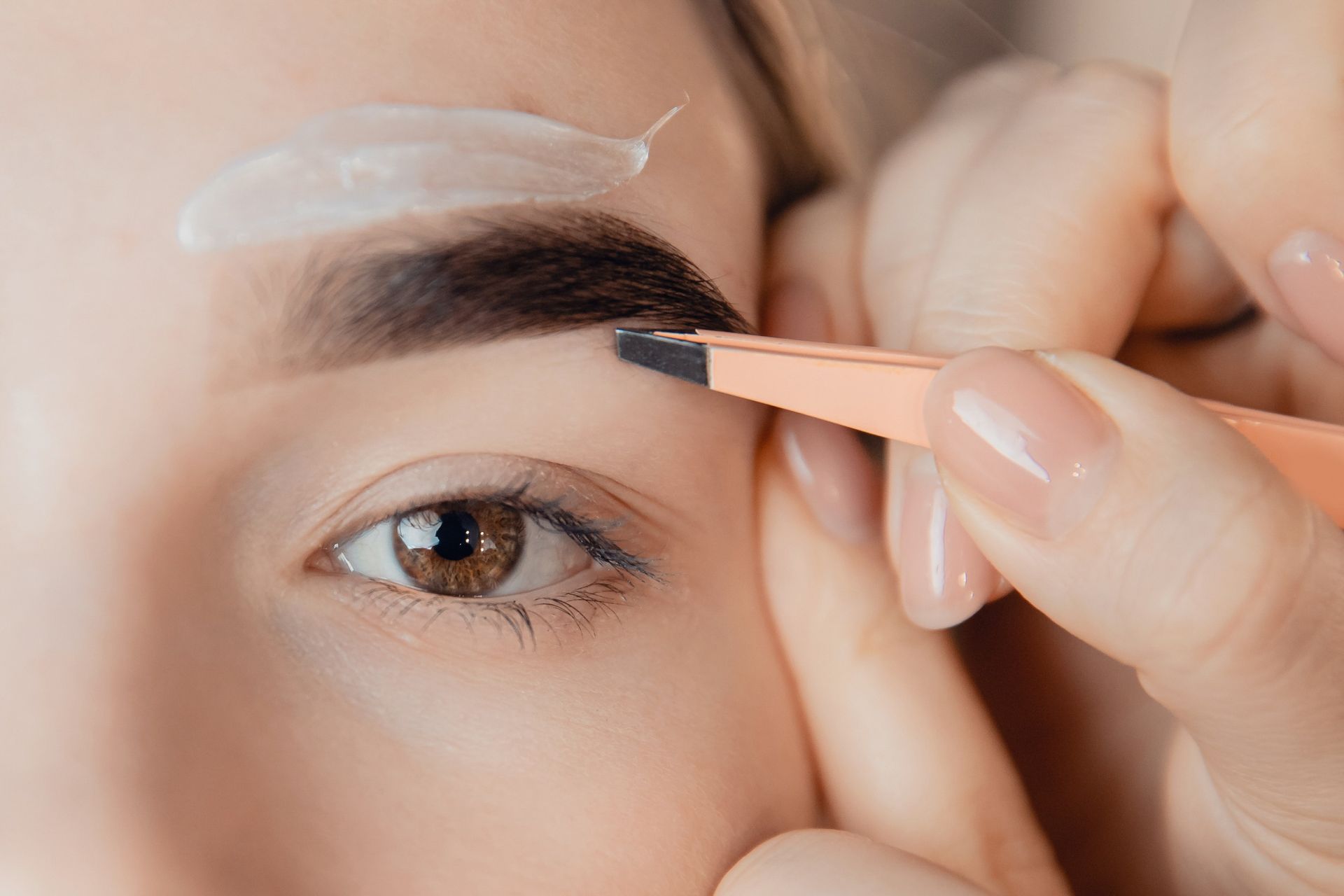 Una mujer se está depilando las cejas con un lápiz.