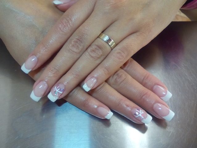 Un primer plano de las uñas de una mujer con un anillo en el dedo.