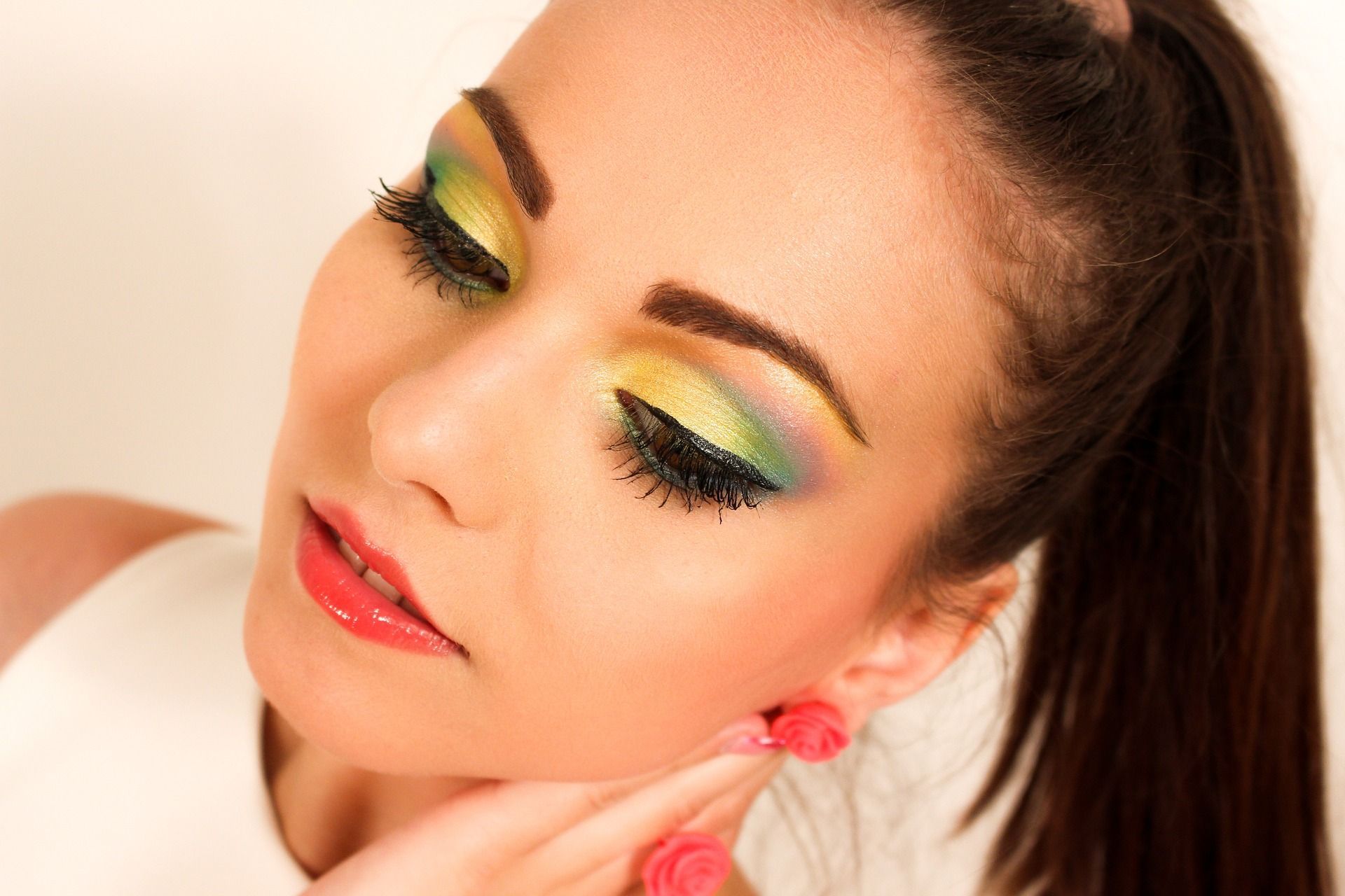 Un primer plano del rostro de una mujer con maquillaje de ojos colorido.