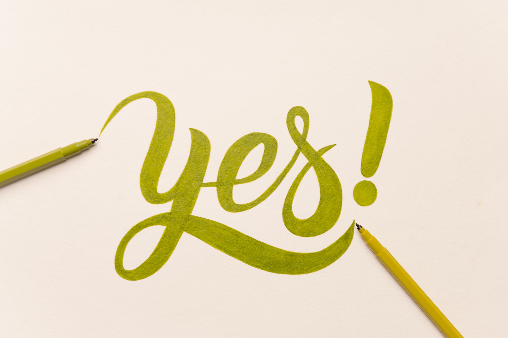 « Oui ! » en écriture cursive jaune au crayon sur fond clair