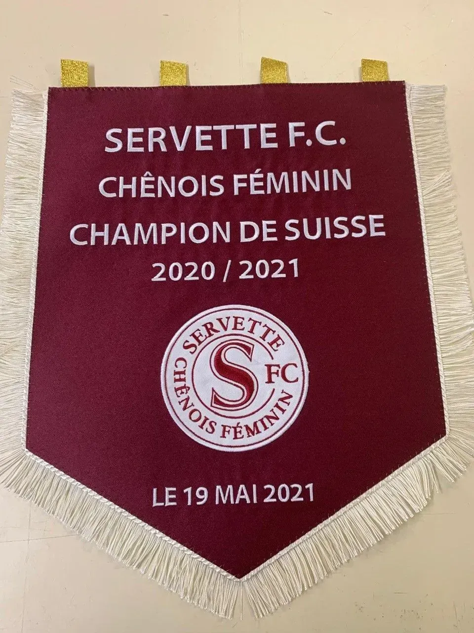 Bannière marron Servette FC CHÉNOIS FÉMININ 2020/2021, championne avec logo du club rouge et franges blanches