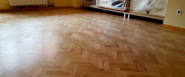 Un suelo de madera en una sala de estar con diseño de espiga.