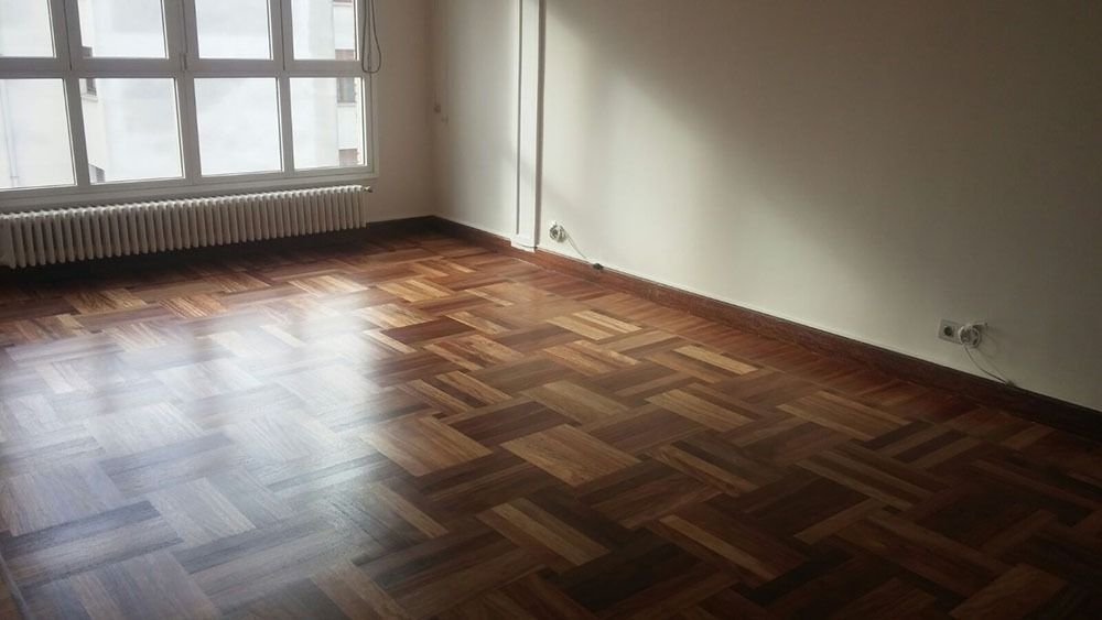 Una habitación vacía con suelo de madera y una ventana.