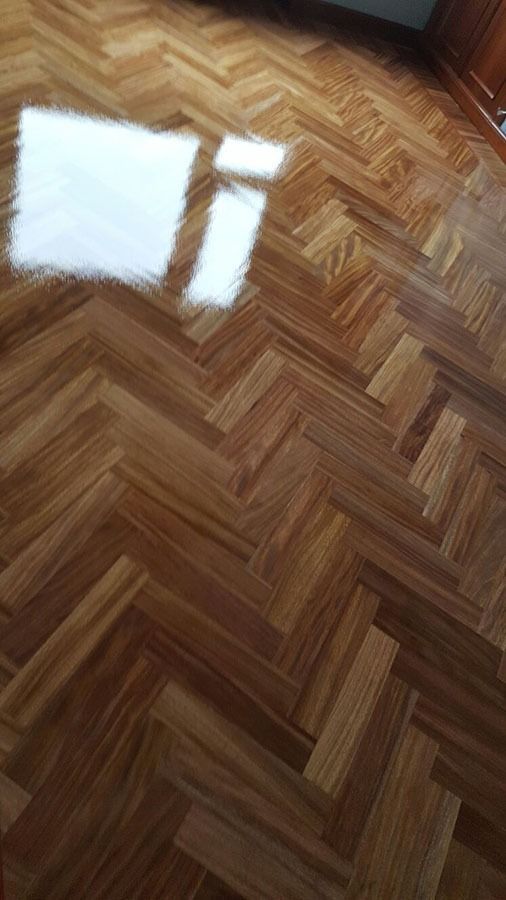 Un primer plano de un piso de madera con patrón de espiga.