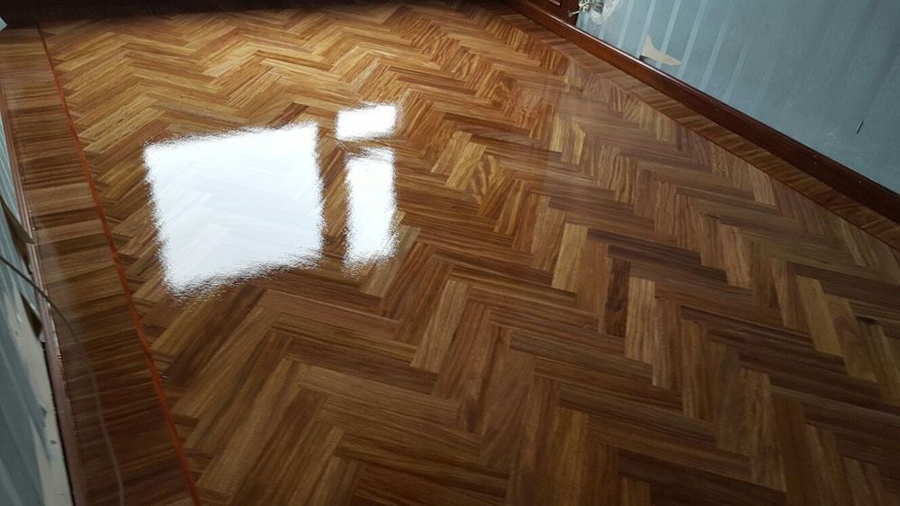 Un suelo de madera con diseño de espiga en una habitación.