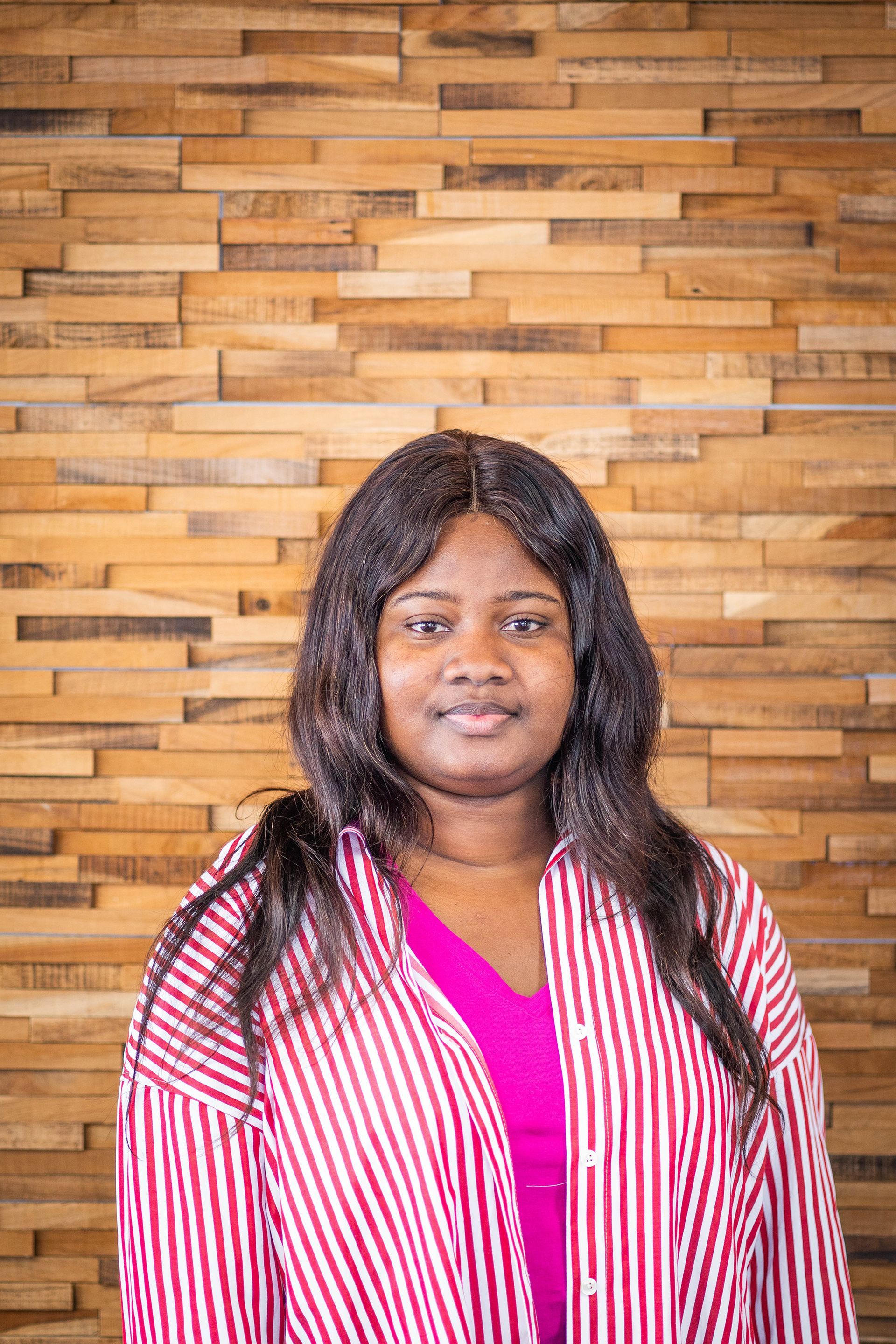 Femme souriante portant des vêtements aux rayures fuchsia et blanches