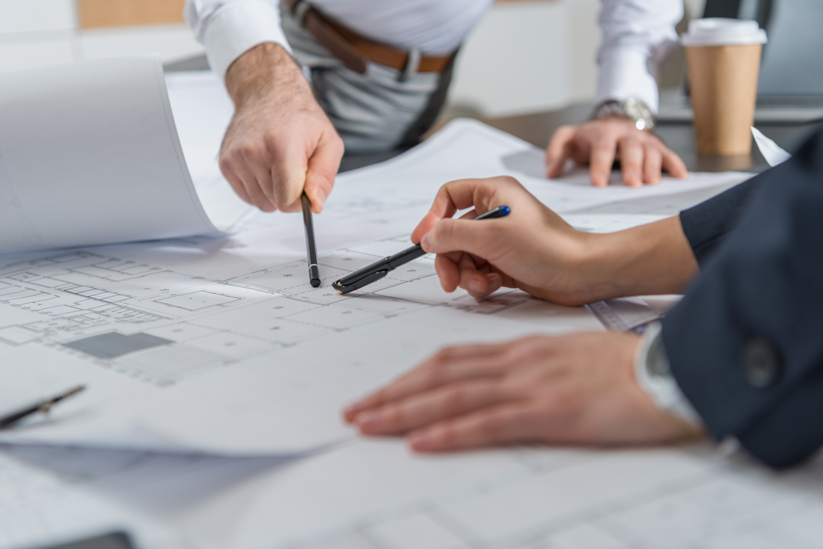 Mains de personnes tenant un stylo et vérifiant des plans