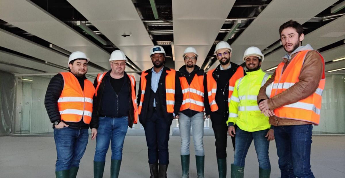 Équipe de sept personnes de bexconsult posant sur un chantier de construction