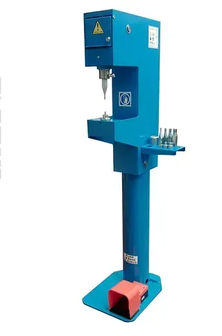 Una máquina azul con un pedal rojo sobre un fondo blanco.
