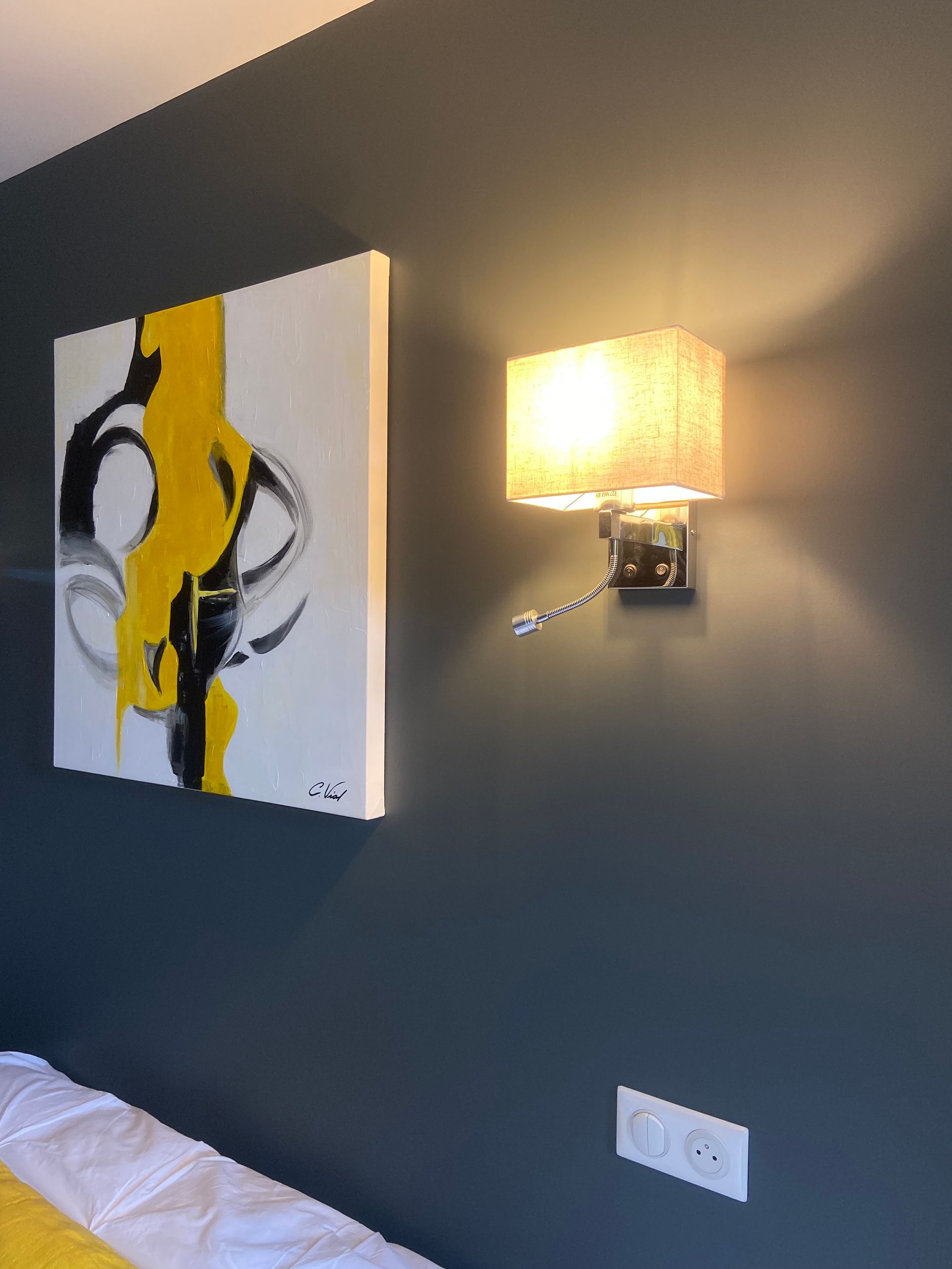 Mur bleu avec un tableau et une applique allumée