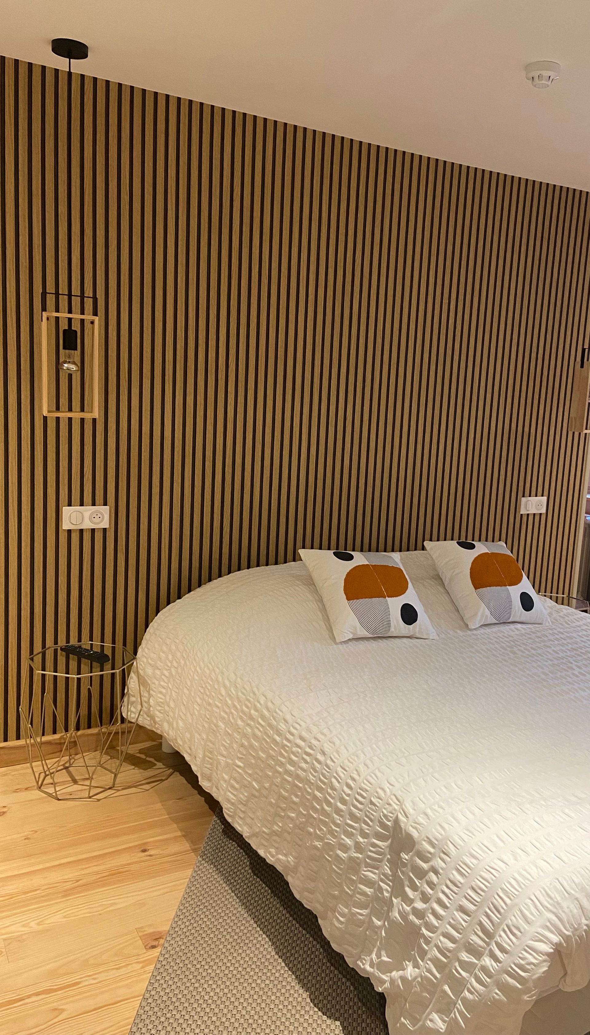 Lit blanc devant un mur en lambris bois