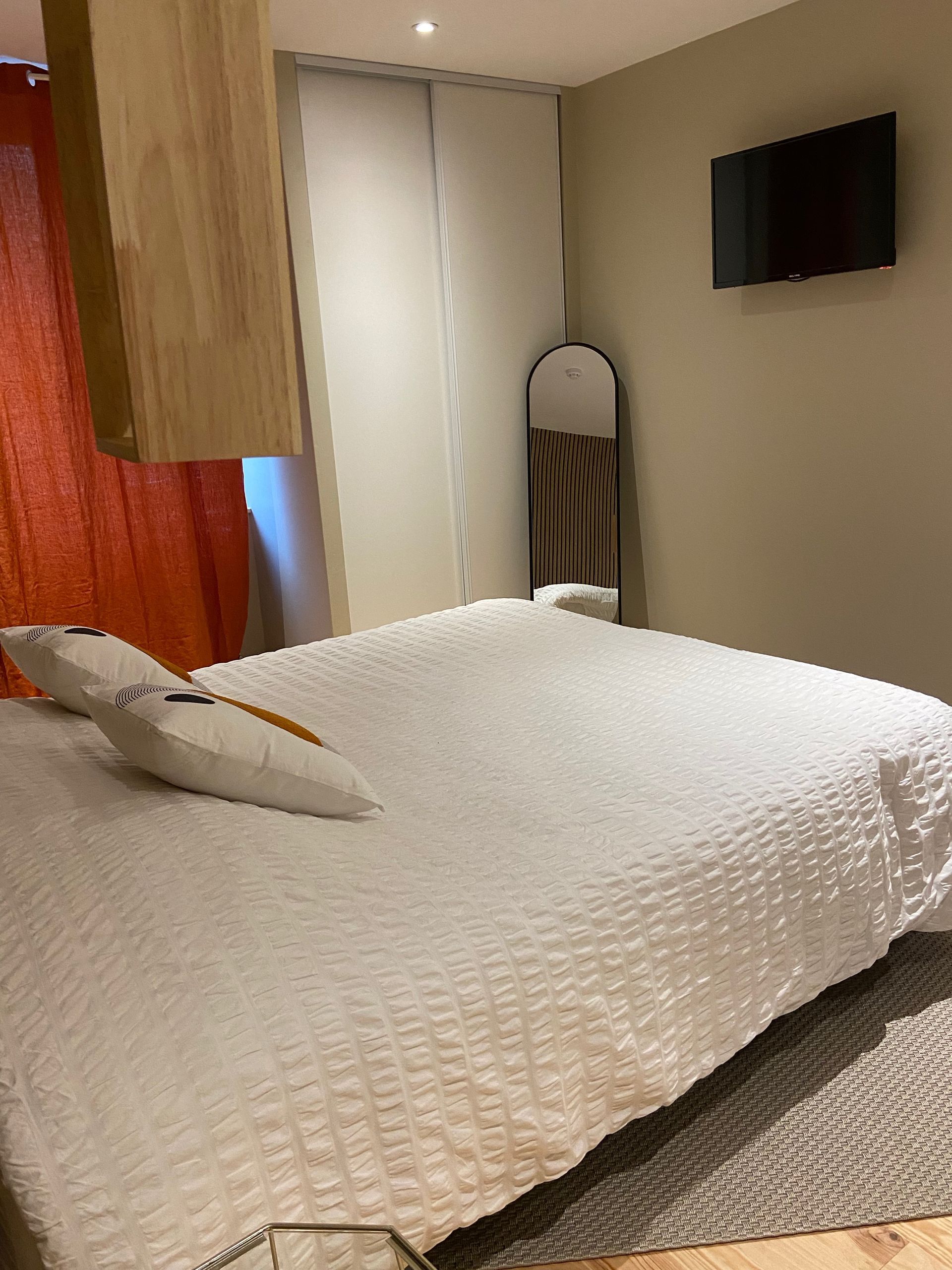 Chambre avec un lit et un miroir dans le coin