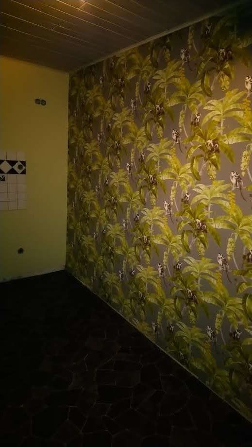 Ein Zimmer mit einer Blumentapete an der Wand.