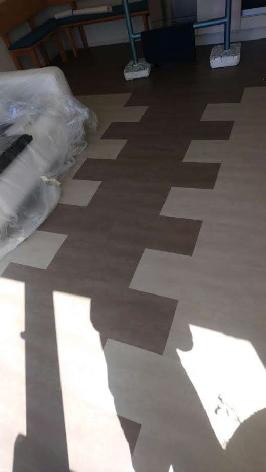 Ein Raum mit Holzboden und dem Schatten einer Person darauf.