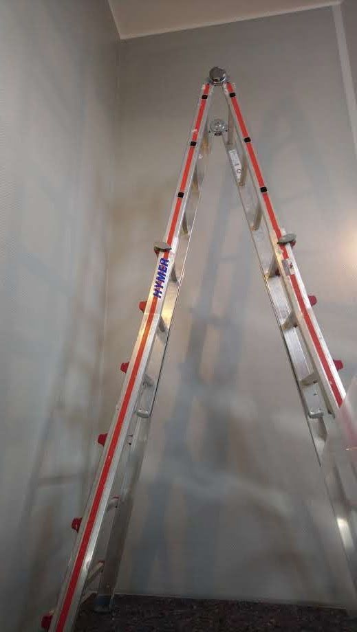 In einem Raum lehnt eine Leiter an einer Wand.