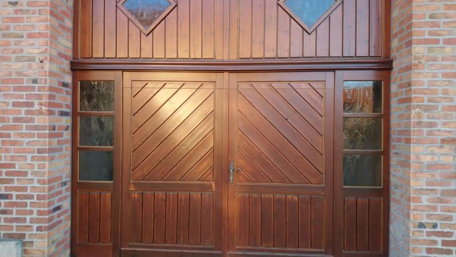 Auf einem Backsteingebäude befindet sich ein hölzernes Garagentor.