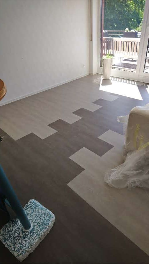 Ein Wohnzimmer mit einem Wischmopp auf dem Boden und einer Couch.