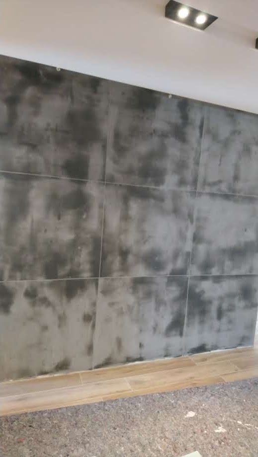 Ein Raum mit einer grauen Wand und einem Holzboden.