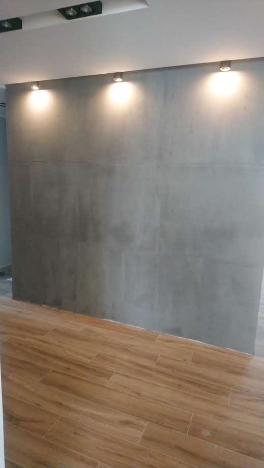 Ein Raum mit Betonwand und Holzboden.