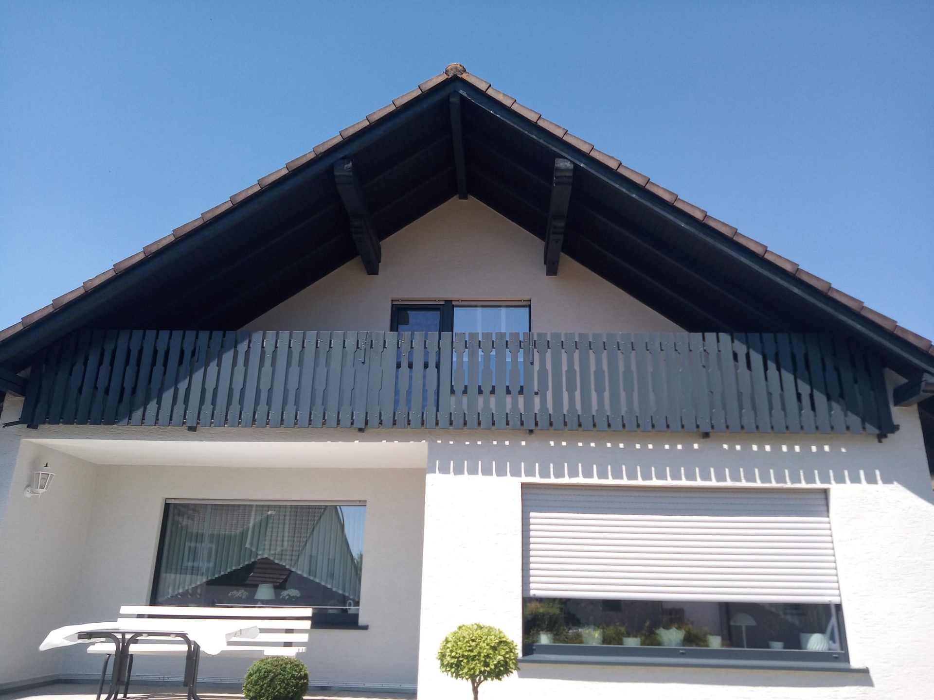 Ein weißes Haus mit Balkon und Fensterläden