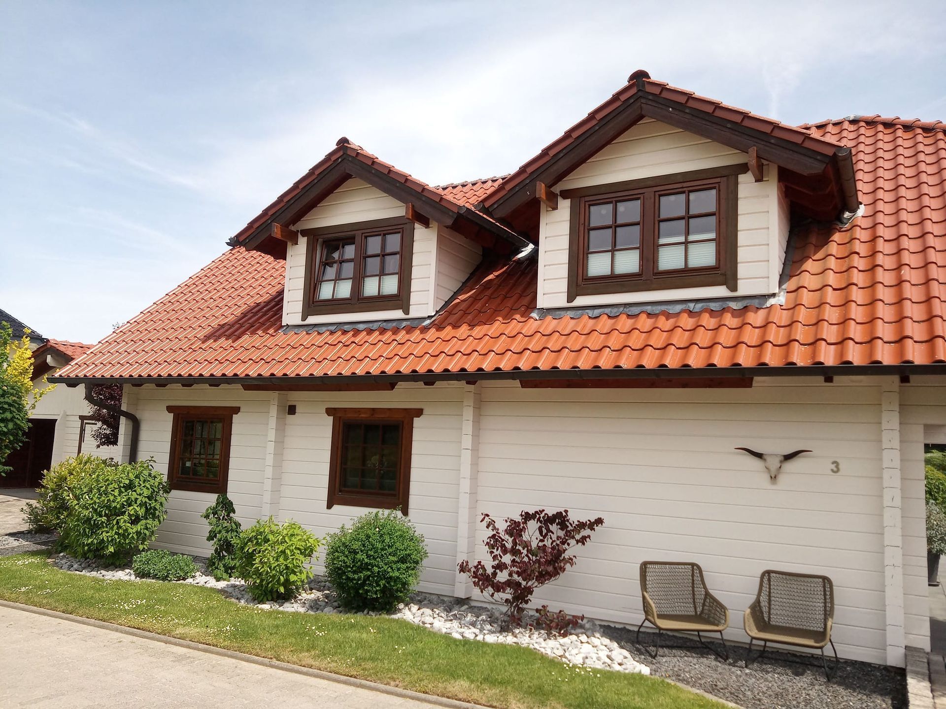 Ein großes weißes Haus mit einem roten Ziegeldach