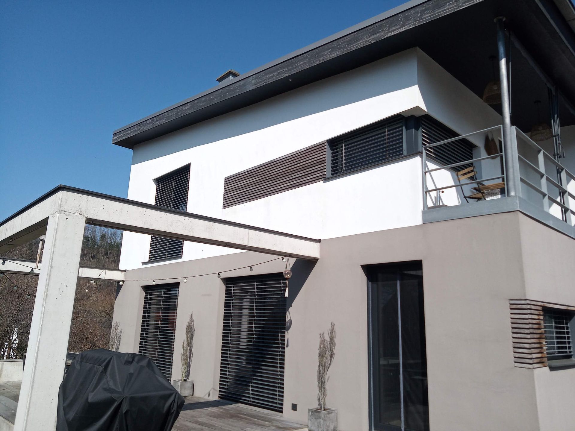 Ein großes weißes Haus mit einem schwarzen Grill davor