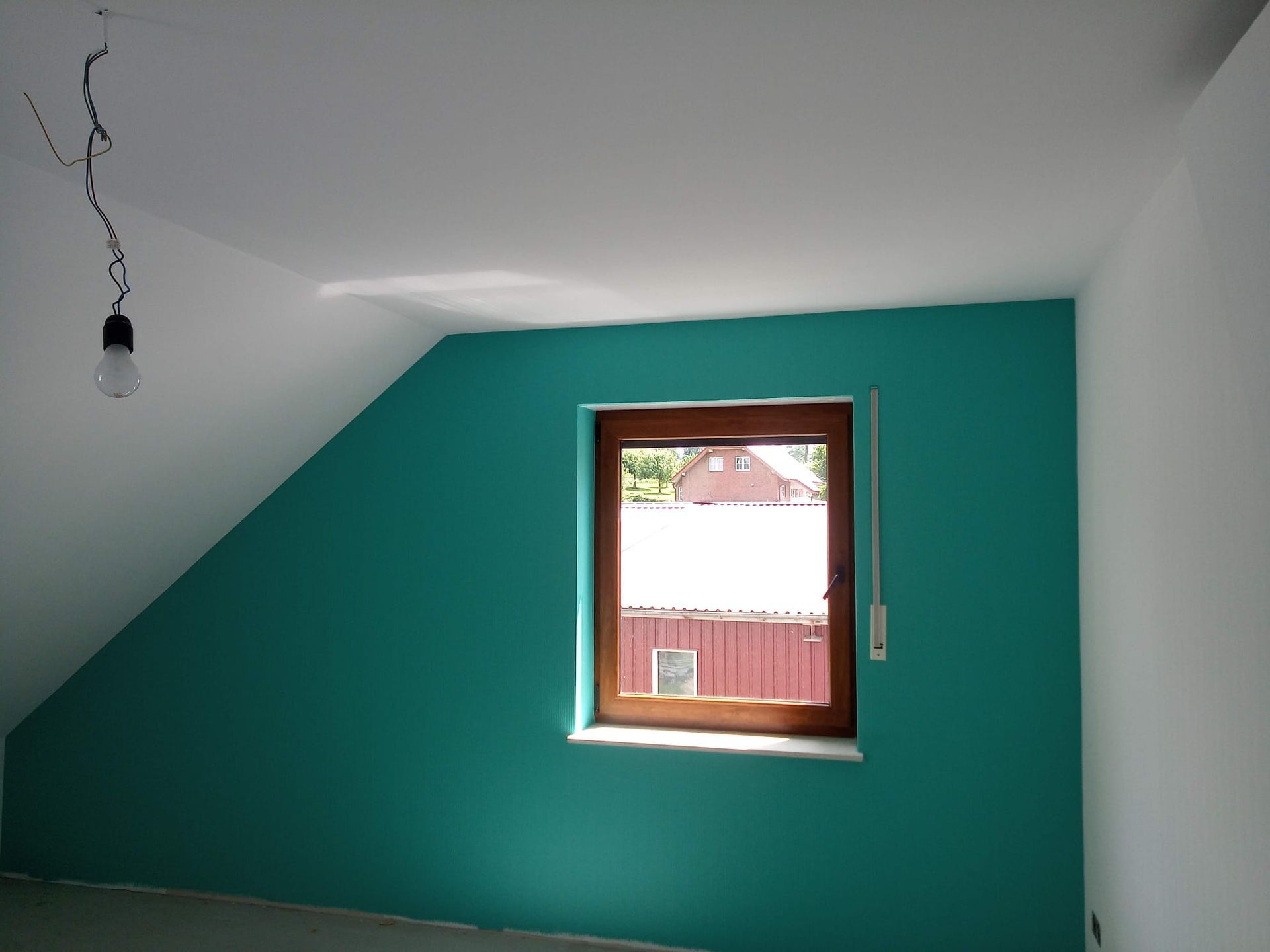 Ein Raum mit einer grünen Wand und einem Fenster