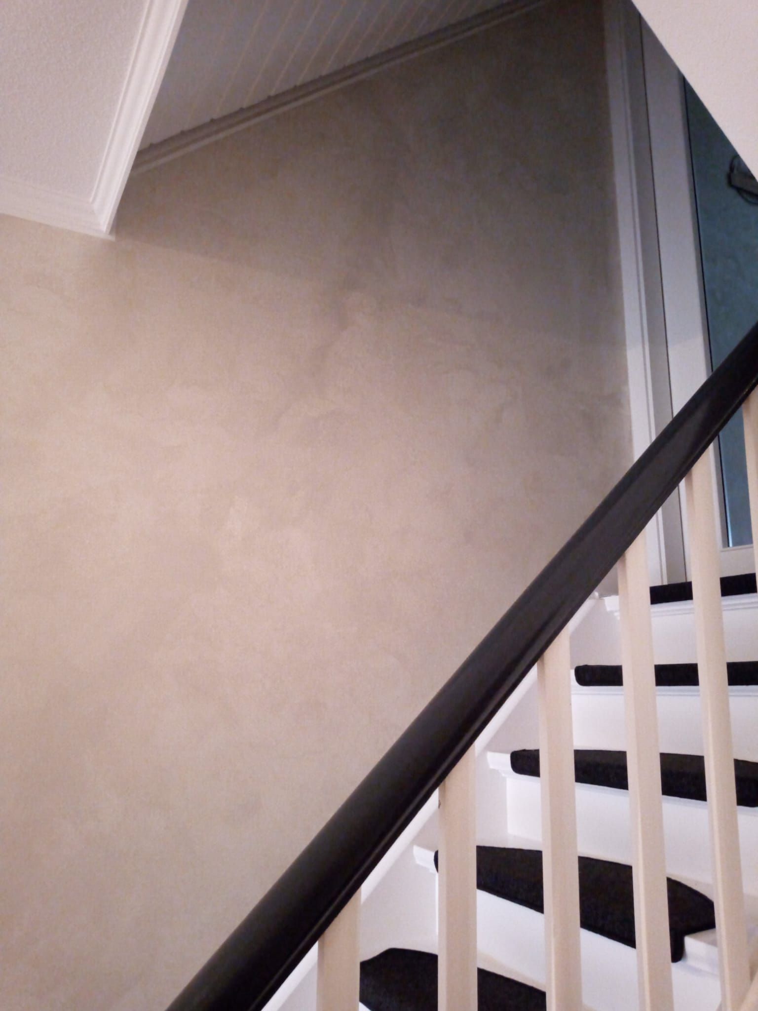 Eine weiße Treppe mit schwarzen Stufen und einem schwarzen Geländer