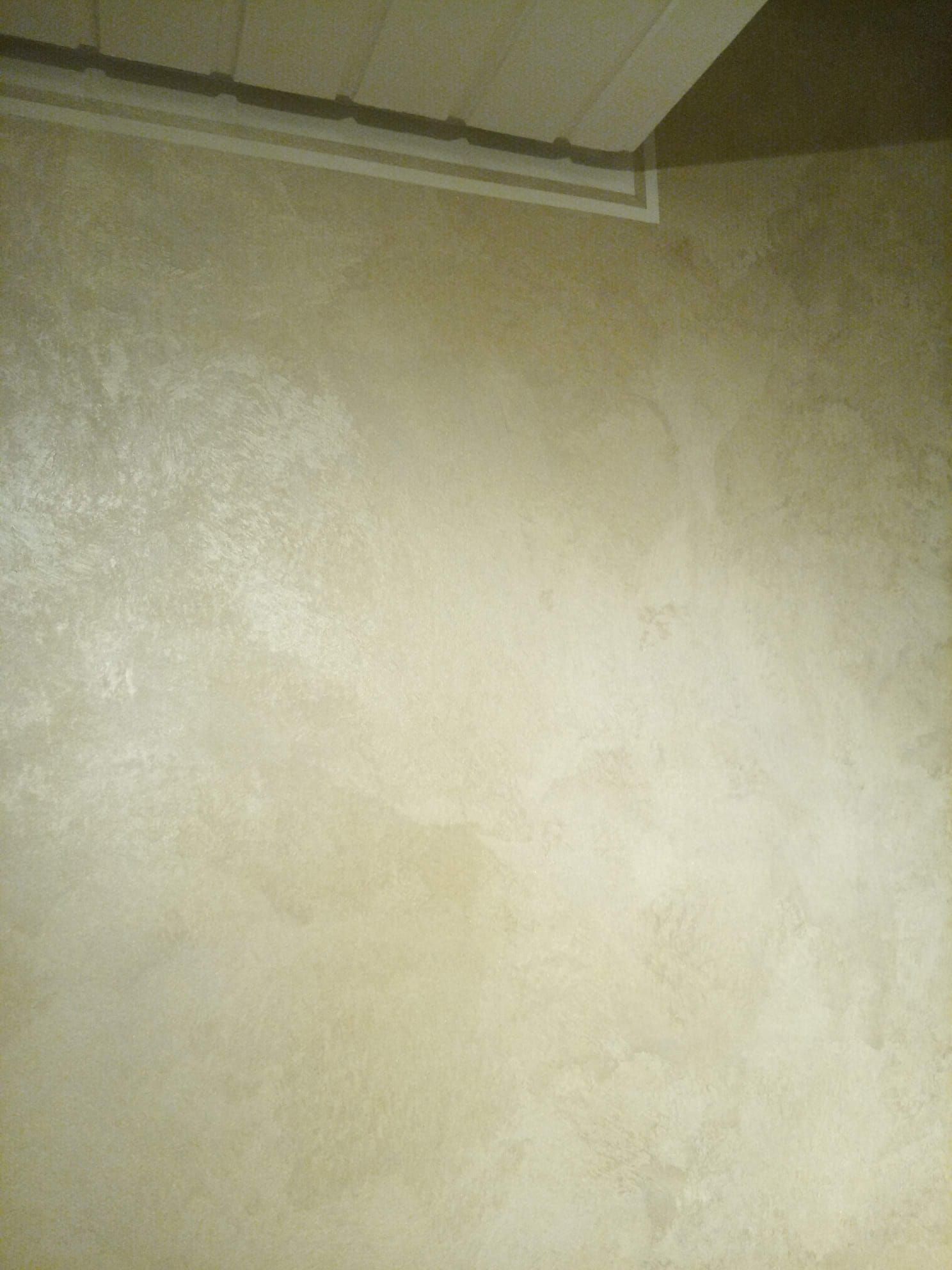 Eine Nahaufnahme einer weißen Wand mit einer Decke im Hintergrund.