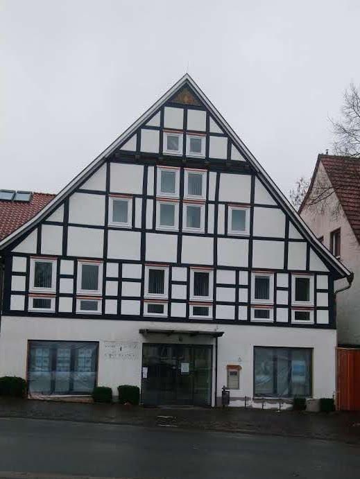 Ein weiß-schwarzes Gebäude mit einem dreieckigen Dach.