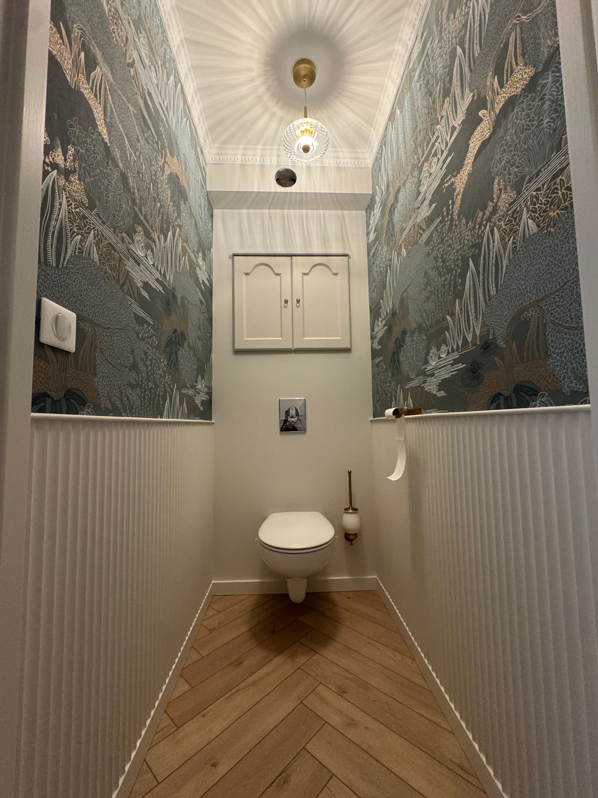 Toilette avec nouveau papier peint et revêtement de sol