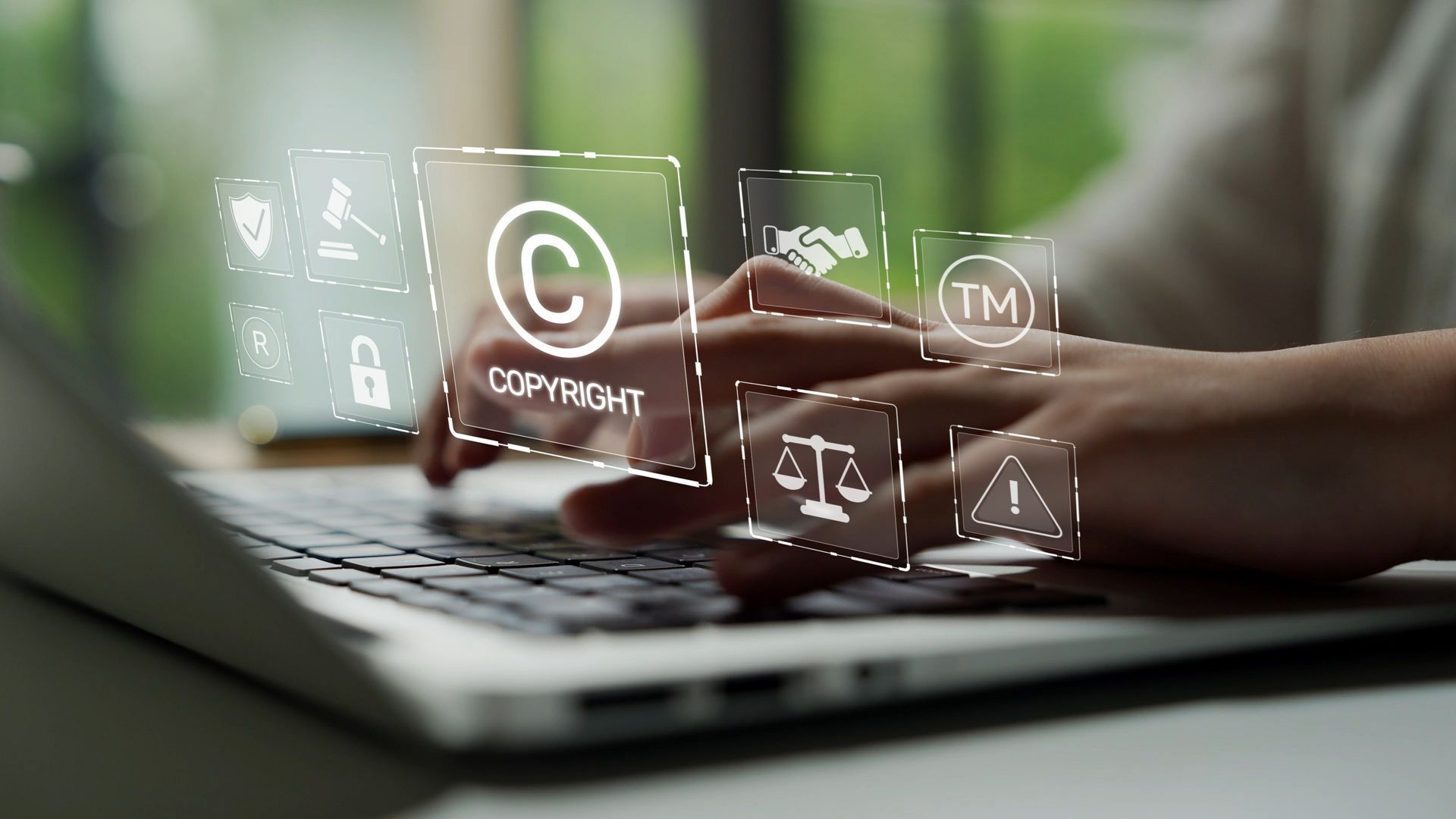 Des mains qui tapent sur un ordinateur portable avec des symboles de copyright superposés.