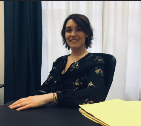 Des mains tenant une silhouette de famille en papier, sur fond de coucher de soleil.