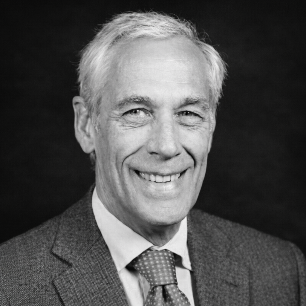 Des colonnes de pierre bordent un couloir, des silhouettes floues se dessinent à l'arrière-plan.