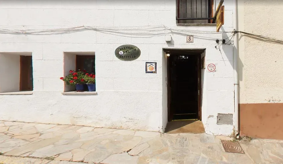 Un edificio blanco con una puerta y una ventana con flores.