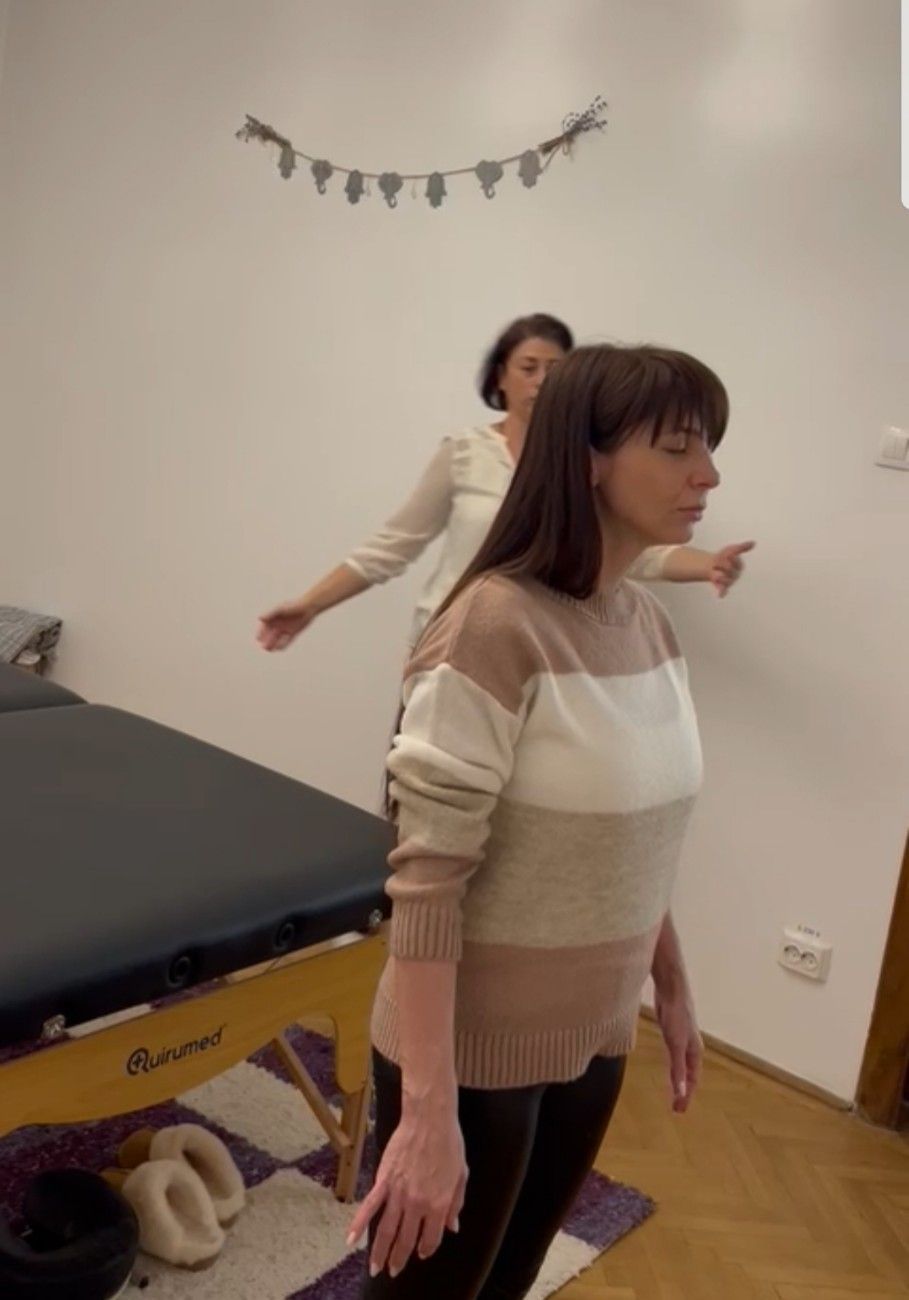 Manos recibiendo masaje de palma sobre una sábana blanca.