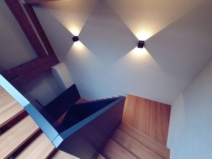 Eine Treppe mit Holzstufen und weißen Wänden