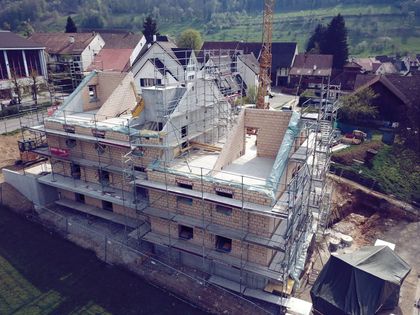 Eine Luftaufnahme eines im Bau befindlichen Gebäudes mit Gerüst und Kran.