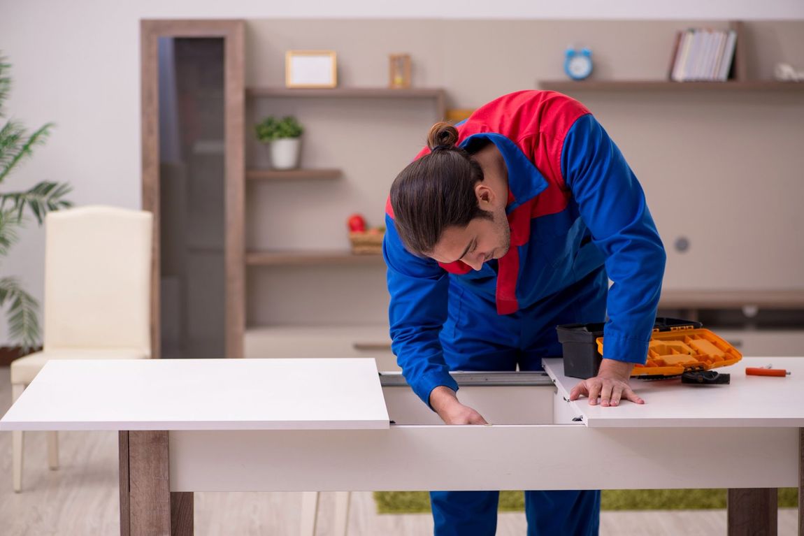 Un hombre está trabajando en una mesa en una sala de estar.