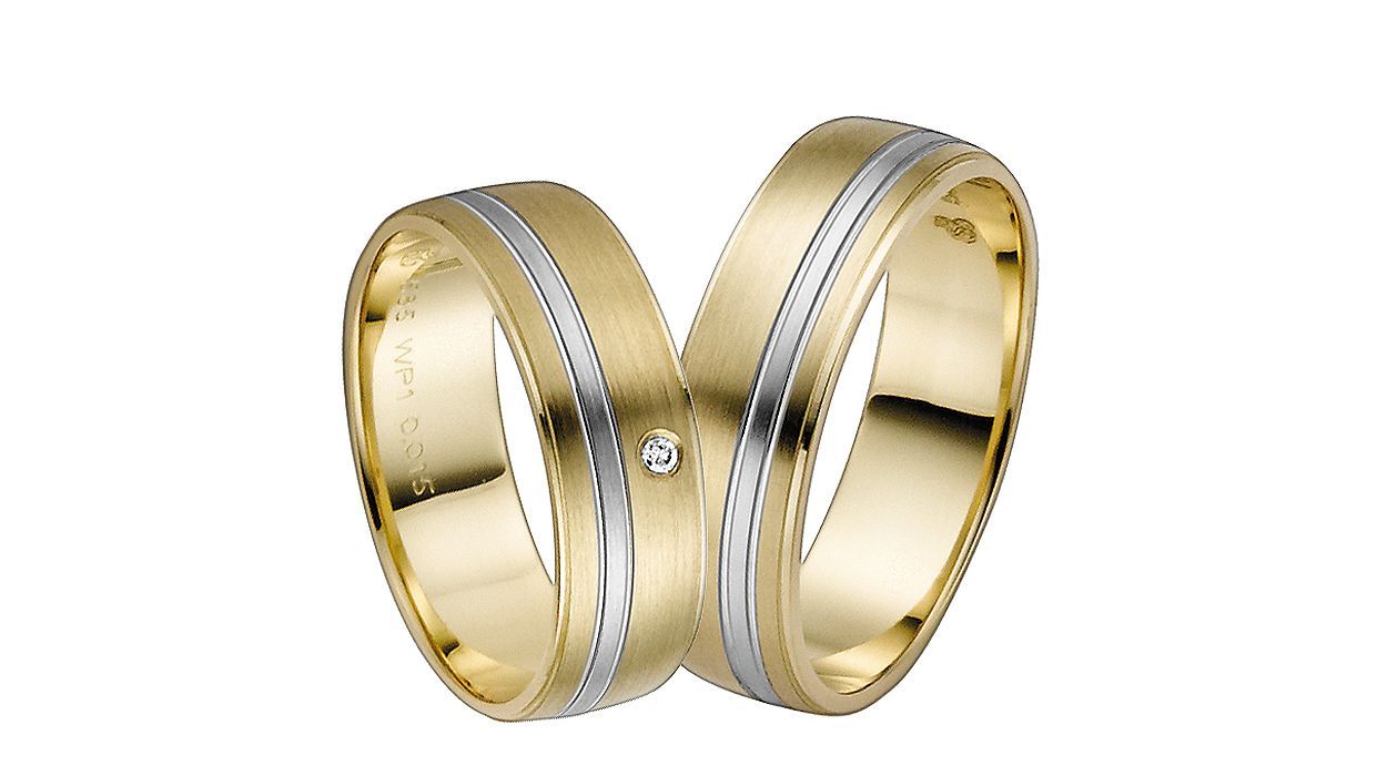 Gelbgoldene Trauringe mit einem schmalen, silbernen Band und einem kleinen Diamanten für die Frau