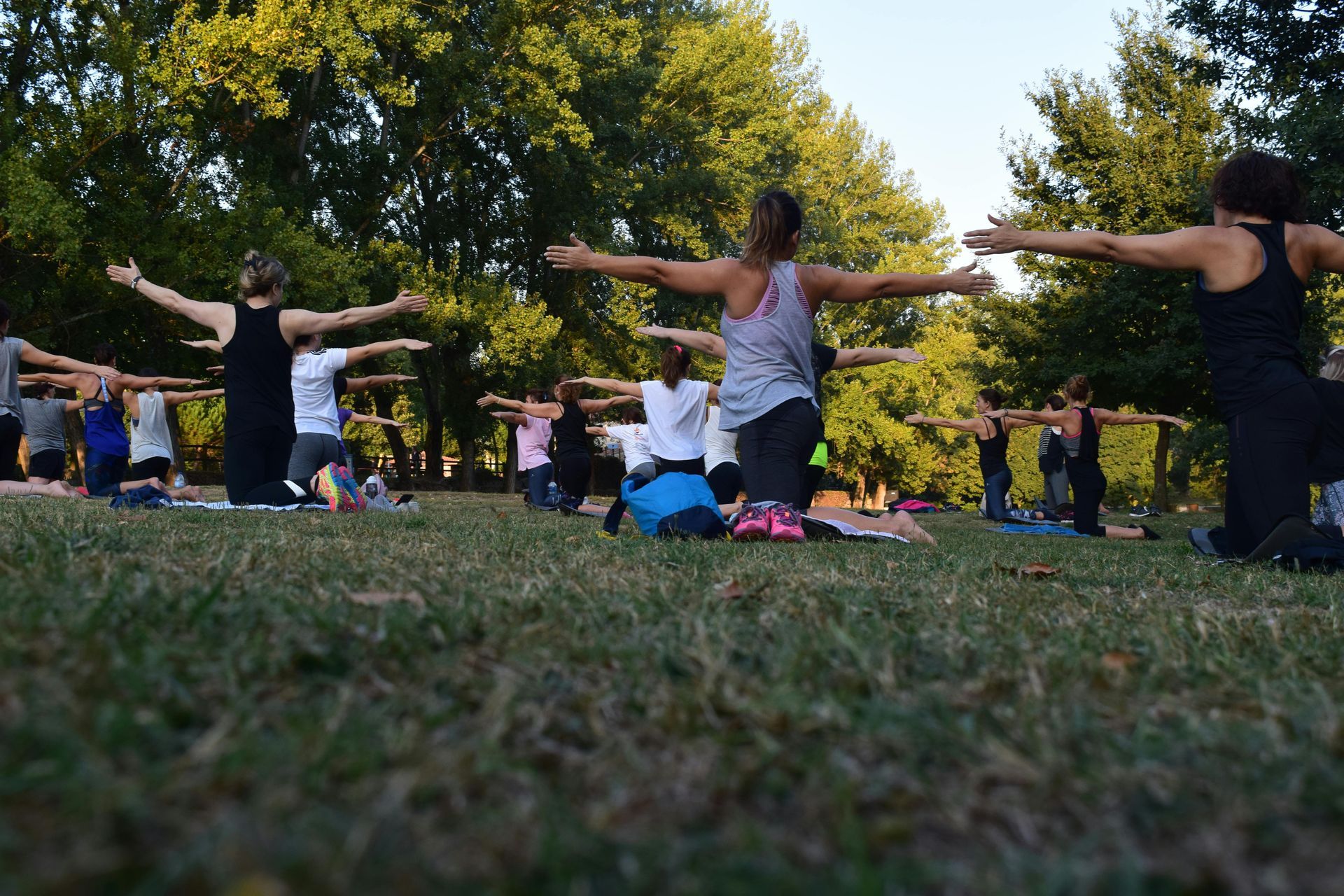 Mujer con traje de yoga morado haciendo una estocada lateral sobre una colchoneta verde