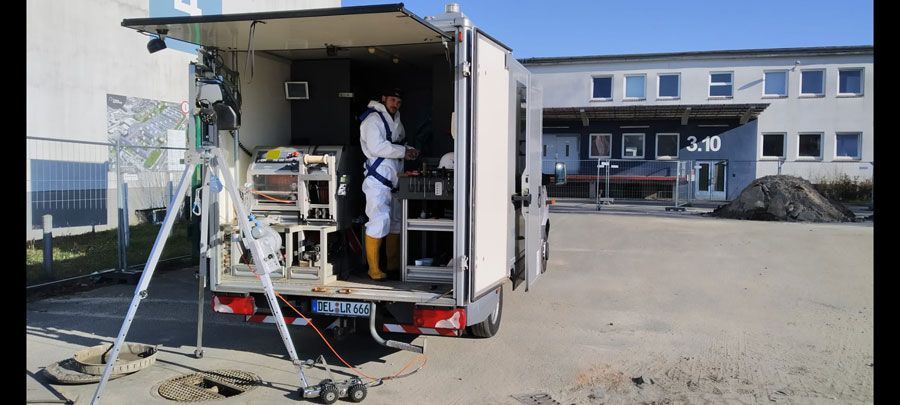 Ein Mann steht auf der Ladefläche eines Lastwagens.