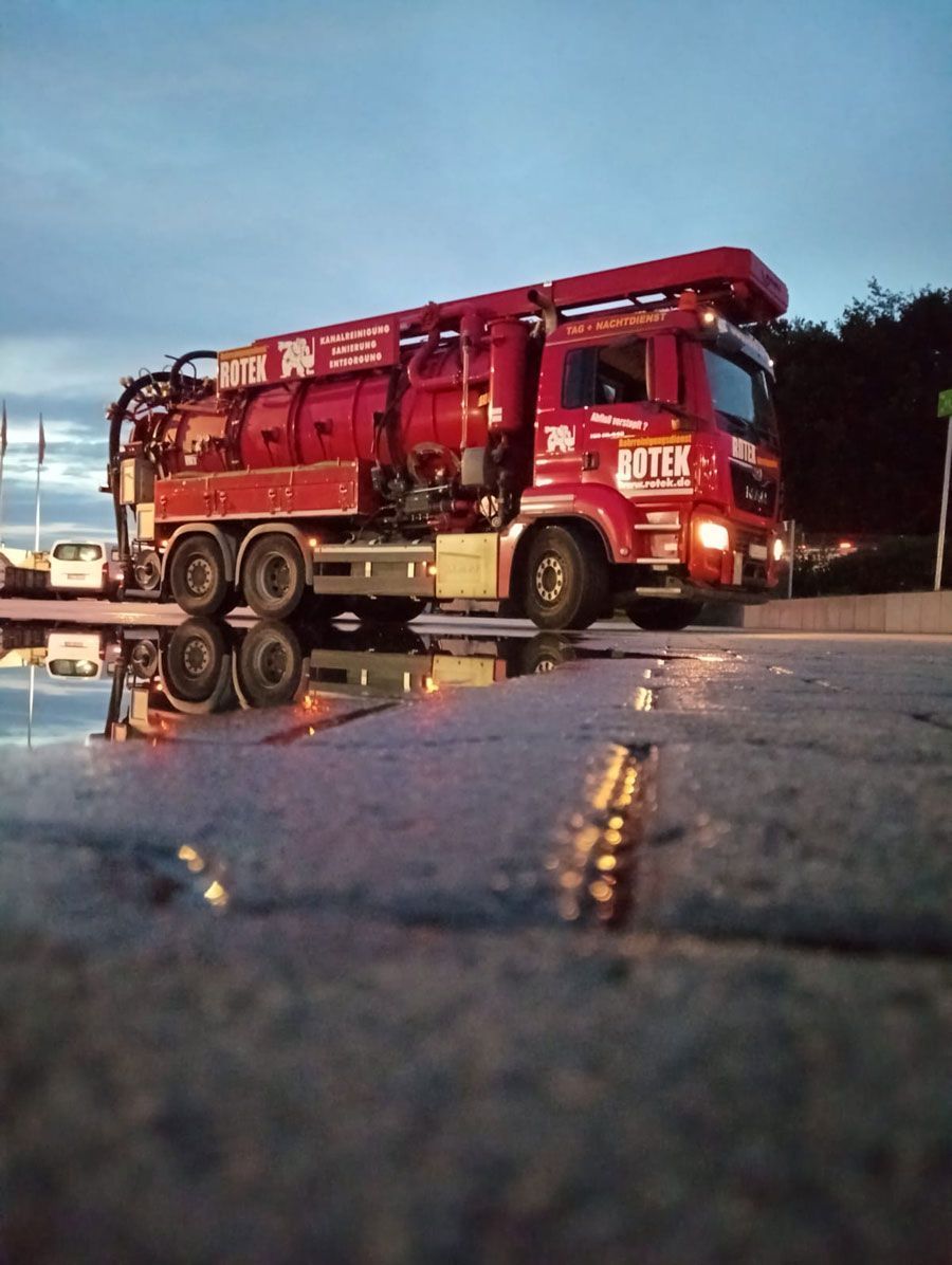 Ein roter LKW steht am Straßenrand